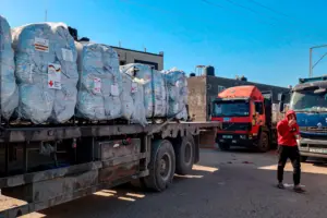 Volunteers on the ground in Gaza receiving and distributing US airdropped supplies, illustrating the collaboration in crisis response.
